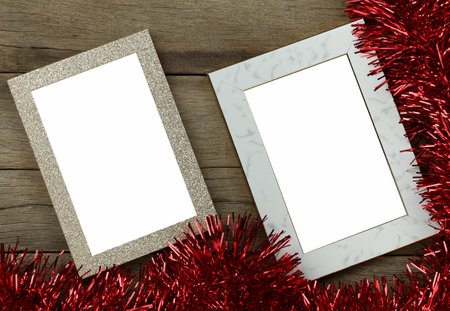 Empty vintage photo frame on wooden floor and red tassels for Christmas and New Year decorations.