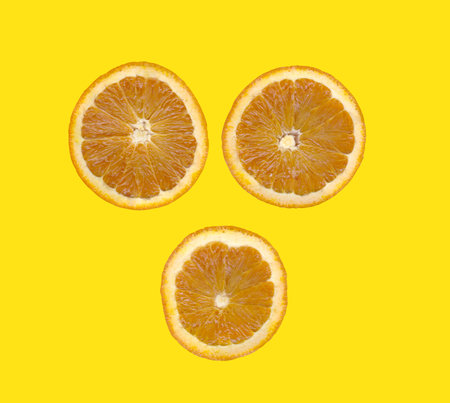 Orange slice isolated on yellow background and have clipping paths.の写真素材
