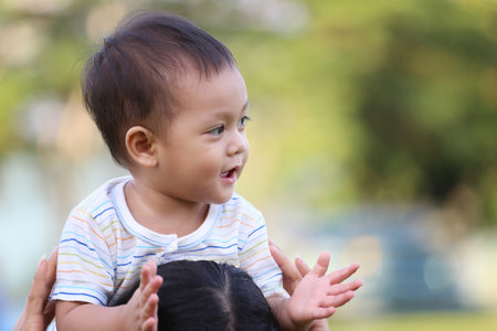 Asian boy is riding his mother's neck and have copy space.の写真素材
