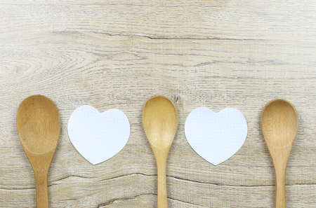 Paper heart shape and wooden spoon placed on the wood floor and have copy space for design in Love and Valentine concept.の写真素材