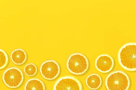 Sliced orange on yellow paper floor and have copy space for design in your summer background...