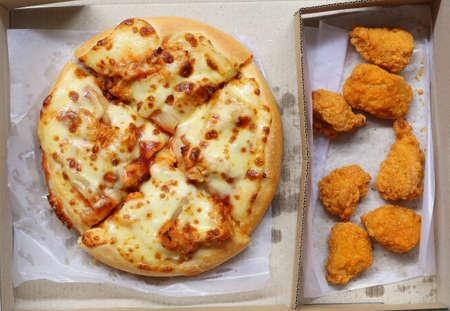 Top view of Pizza in brown paper box and fried chicken, a junk food lunch set.の写真素材