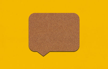 Brown paper speech bubble on yellow paper background. Paper blank of text box with copy space for advertisement design.の写真素材