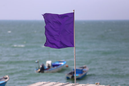 Empty Purple flag on the roof was waving with the wind from the sea.