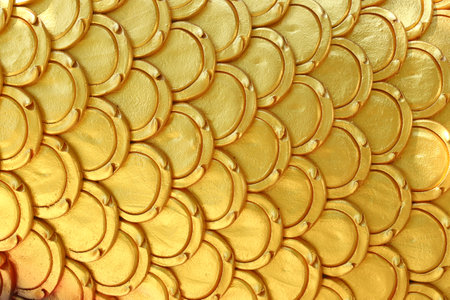 Gold patterns of stucco shaped like fish scales, Background of stacked golden flakes for design in your work.の写真素材