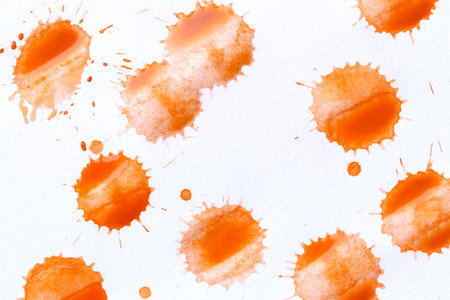 Orange color paint drops on paper, causing dispersion of color, use it for design your work concept.の写真素材