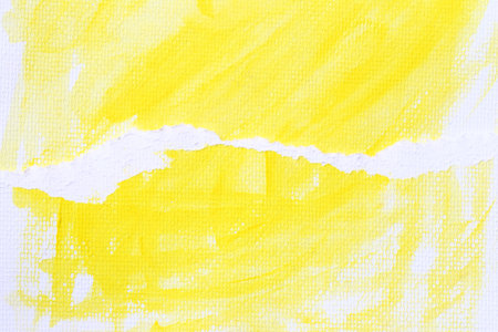 Yellow watercolour paint brush on the white art paper background and There are tears in the overlapping papers.の写真素材