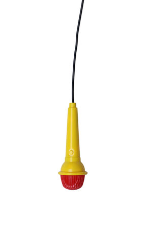 Children's toy microphone is yellow and has a black wire plugged into it with isolated on white...