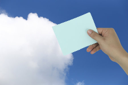 Businessman hands with blue paper note with clouds in the background and shaped like smoke coming out of sound broadcasting.の写真素材