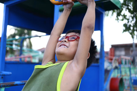 A joyful child smiles while playing on colorful playground equipment, showcasing the essence of...