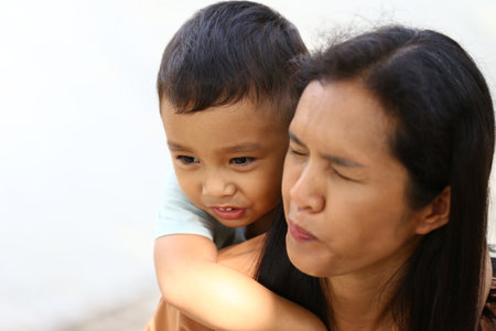 A joyful moment captured between a mother and her child, showcasing their playful bond and the warmth of family love in an outdoor setting.の写真素材
