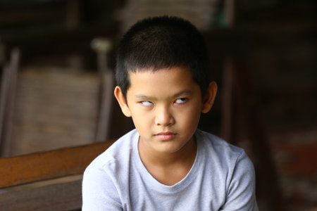 A playful boy displays a unique expression indoors, reflecting curiosity and emotion. This candid portrait captures childhood innocence and personality beautifully.の写真素材