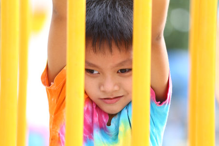 A joyful child enjoys playing at a colorful playground, demonstrating innocence and curiosity as he interacts with vibrant play equipment.の写真素材