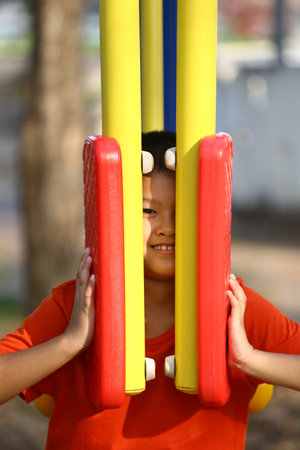 A joyful child enjoying playtime at a vibrant outdoor playground. The bright colors of the equipment create a cheerful atmosphere for fun and exploration.の写真素材