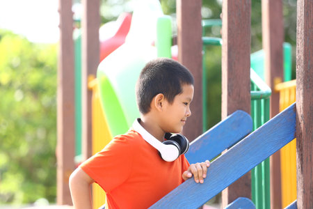 A cheerful child enjoys playing at a vibrant playground, climbing steps and engaging in joyful activities, surrounded by colorful play structures and natural light.の写真素材