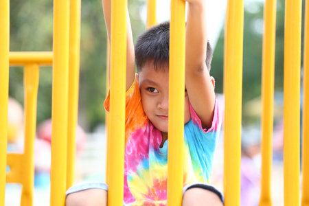 A cheerful child enjoys playing on vibrant yellow playground equipment, radiating joy and curiosity in an outdoor setting perfect for exploration.の写真素材