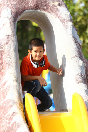 A cheerful child enjoys a playful moment on a vibrant playground slide, capturing the essence of childhood joy and outdoor fun in a bright setting.の写真素材