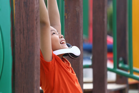 A joyful child enjoys a bright day on the playground, showcasing happiness while engaging in playful...