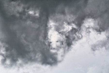 Captivating image of dark storm clouds swirling in the sky, creating a dramatic and atmospheric scene. Ideal for weather-related projects or nature themes.の写真素材
