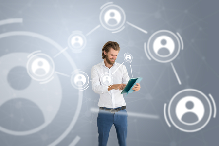 Happy business man with tablet and people  icons to illustrate communication.の写真素材