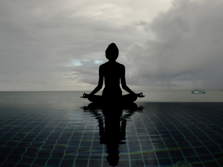 silhouette woman yoga on the edge pool sea viewの写真素材