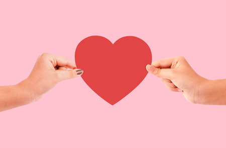 Couple arms holding heart isolated on pink backgroundの写真素材