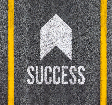 Success word with arrow on asphalt roadの写真素材