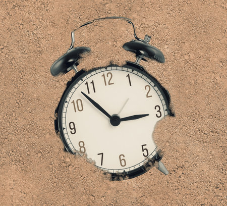 Black clock buried and lost in the sand. lost time concept