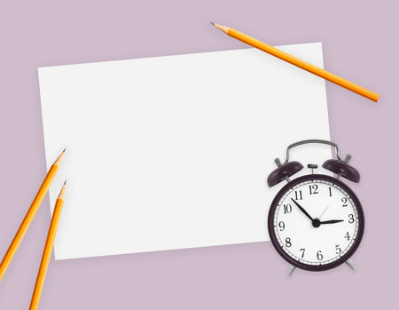 Blank sheet of paper, alarm clock and pencils, flat lay. education and study conceptの写真素材
