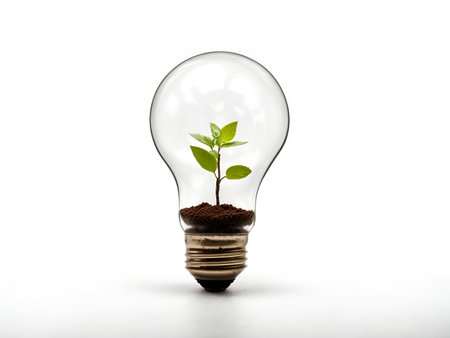 A light bulb filled with soil and a small, sprouting plantの素材