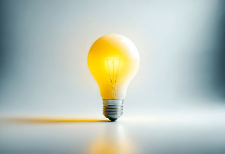 a yellow light bulb against a white backgroundの素材