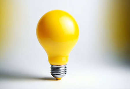 a yellow light bulb against a white backgroundの素材