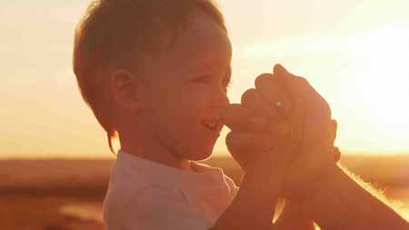 boy with his father on the beach at sunset happy familyの写真素材