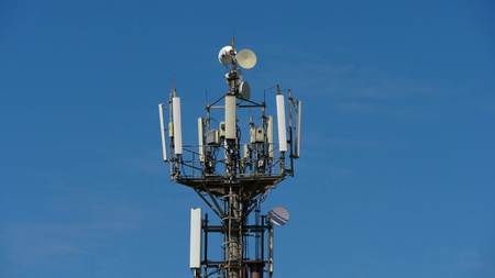 telecommunication cellular tower against blue sky, with room for copy spaceの写真素材