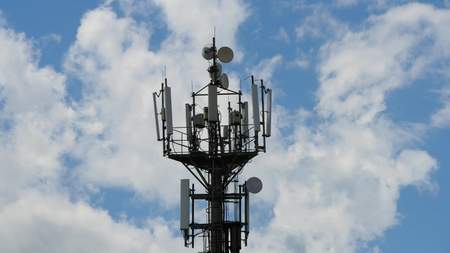 telecommunication cellular tower against blue sky, with room for copy spaceの写真素材