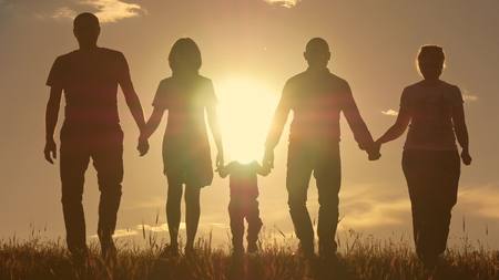 Happy young family with children running around the fieldの写真素材