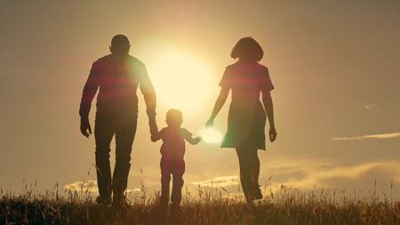 Happy young family with children running around the fieldの写真素材
