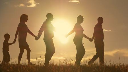Happy young family with children running around the fieldの写真素材