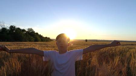 Little girl running cross the wheat field at sunset.Slow motionの写真素材