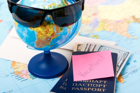 Passports money tickets globe and map of the world as a vacation concept. Summer journey preparation. Planning holidays cheking documents choosing destination point having fun.の写真素材