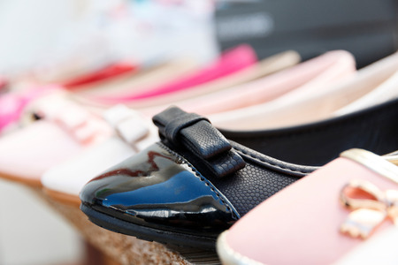 Row of different coloured women's shoes on market. Examples of new season female footwear collection  in a line in shop. Sales and discount concept.の写真素材