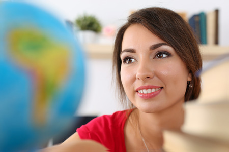 Young beautiful female student searching something on globe. Geography, politics, culture or history lesson concept. Education, studying, learning, teaching, self development and perfection conceptの写真素材