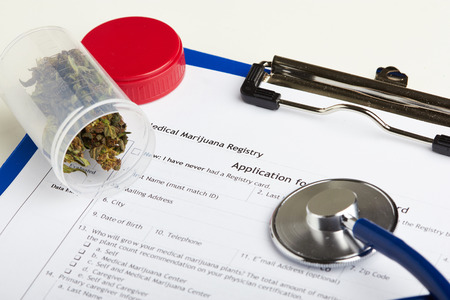 Medical marijuana in jar lying on prescription form near stethoscope. Cannabis recipe for personal use. Legal drugs conceptの写真素材