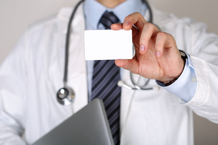Male medicine doctor hand holding blank calling card.の写真素材