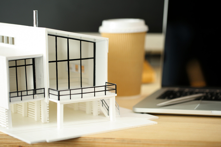 Empty architect working table with house model. Creative people or advertising business concept