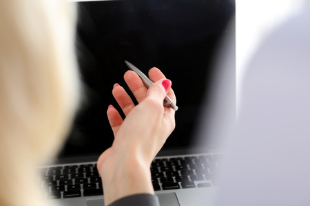 Hand of businesswoman poinnt in laptop pc display in office closeup. Situation review, white collar gesture, income report, analytics and support, professional training, discuss problem conceptの写真素材