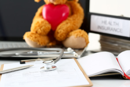 Silver pen and phonendoscope head lying at patient history listの写真素材