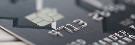 Embossed chipped credit card lying on silver keyboardの写真素材