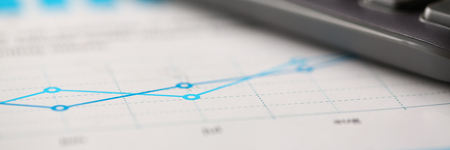 Black calculator and financial graph paper statistics