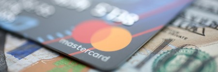 Minsk, Belarus - February 08,2017: Embossed chipped mastercard credit card and hundred dollar bank notes closeupのeditorial素材